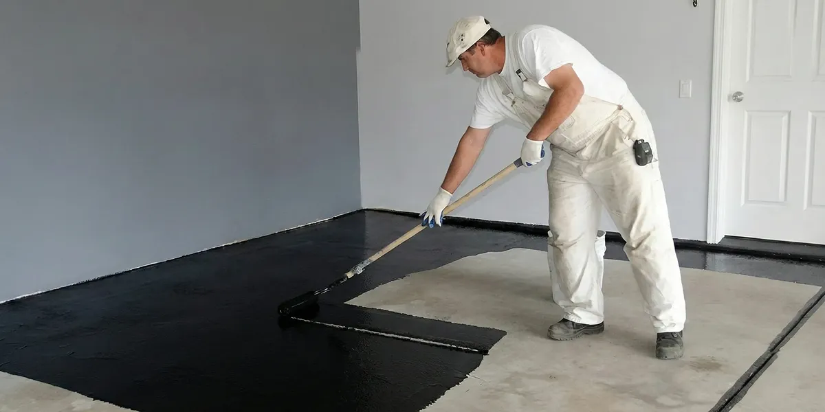 basement waterproofing professional applying waterproof coating to protect a basement floor in Sarasota, FL