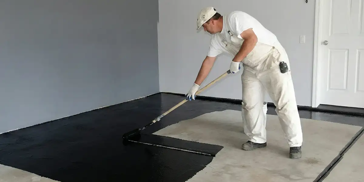 basement waterproofing professional applying waterproof coating to protect a basement floor in Sarasota, FL